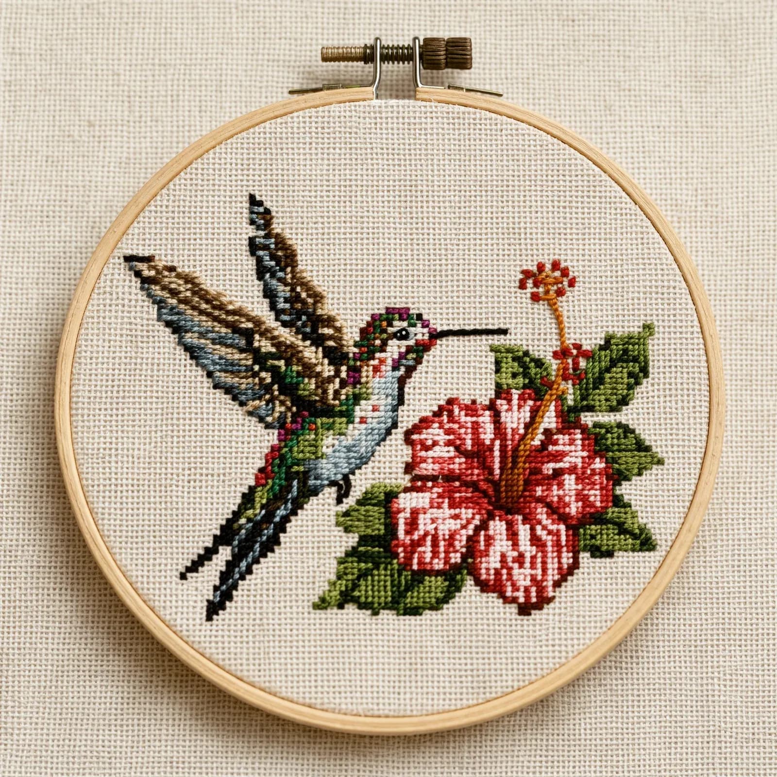 Cross-stitch hummingbird and hibiscus in an embroidery hoop